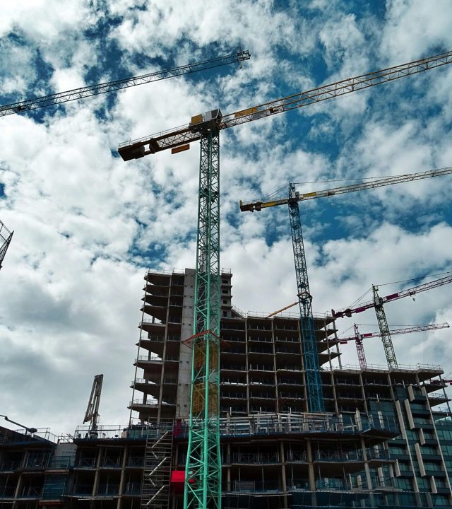 pexels-photo-439416-439416 Urban construction site with numerous cranes framing rising skyscrapers against a blue sky.